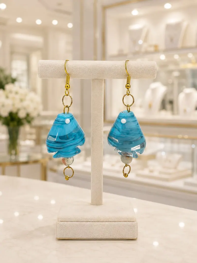 Brincos de vidro azul em forma de gota, num expositor